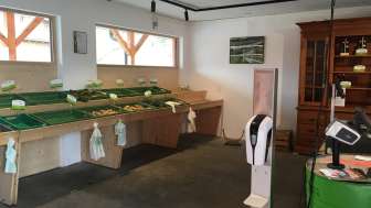 Selbstbedienungsbereich des Birkahoflädile mit leeren Verkaufstischen und grüner Kasse – nachhaltiger Hofverkauf in Liechtenstein.