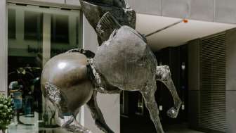 Bronzeskulptur „Grande Cavallo“ von Nag Arnoldi zeigt ein aufbäumendes Pferd vor modernem Gebäude in Vaduz.