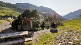 Grillplatz Schlucher-Treff mit Sitzbank, Feuerstelle und Blick ins Liechtensteiner Bergpanorama bei Sonnenschein