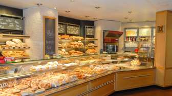 Blick auf den Verkaufsraum der Bäckerei Konditorei Amann mit gefüllter Theke und vielen Leckereien