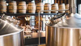 Blick von oben auf Brauereianlage mit Sudkesseln und Holzfässern im Liechtensteiner Brauhaus