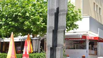 Skulptur „Monoform 29“ von Gottfried Honegger aus grauem Stein mit vertikalem Einschnitt – moderne Kunst in Vaduz.