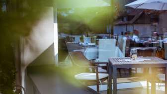 Detailaufnahme von Terrassenmöbeln im Freien, mit sanfter Lichtstimmung und grüner Umgebung