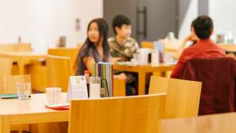 Gäste sitzen im hellen Café-Bereich des Kunstmuseums und unterhalten sich