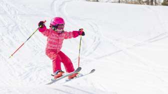 Kind in rosa Skianzug am Skifahren in Malbun