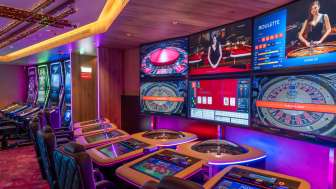 Moderne Spieltische mit digitalen Bildschirmen und mehreren Roulette- und Kartenspieloptionen im stimmungsvoll beleuchteten Casino Schaanwald.