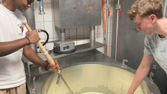 Besucher am Käse machen